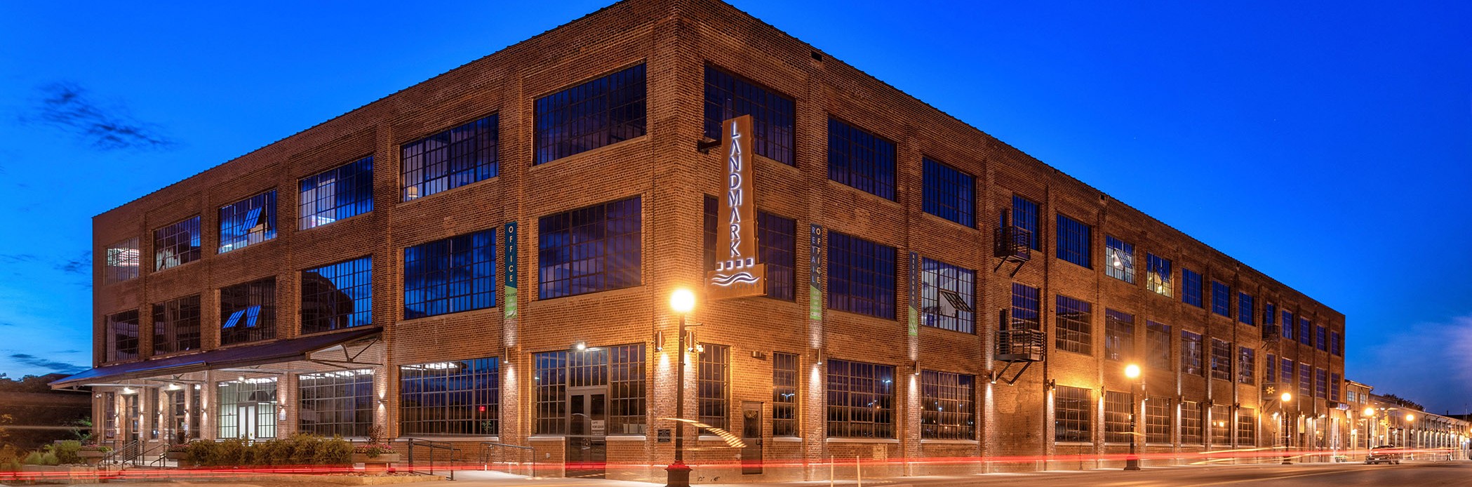 Brown three story office building exterior at dusk